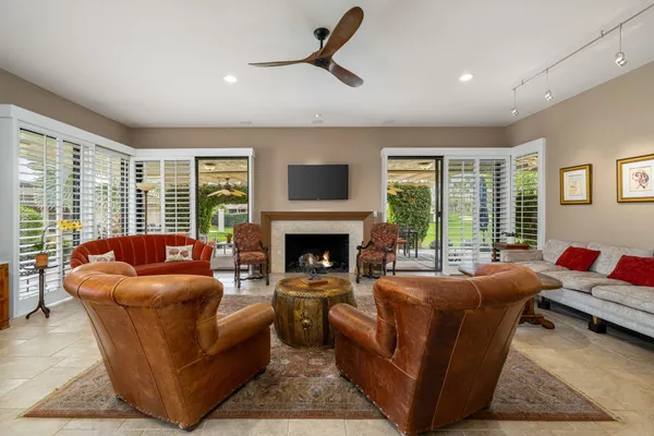 a living room with furniture a fireplace and a large window