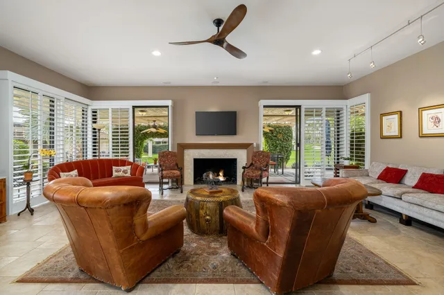 a living room with furniture a fireplace and a large window