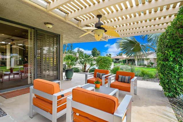 a dining hall with stainless steel appliances granite countertop a stove a sink a oven a dining table and chairs