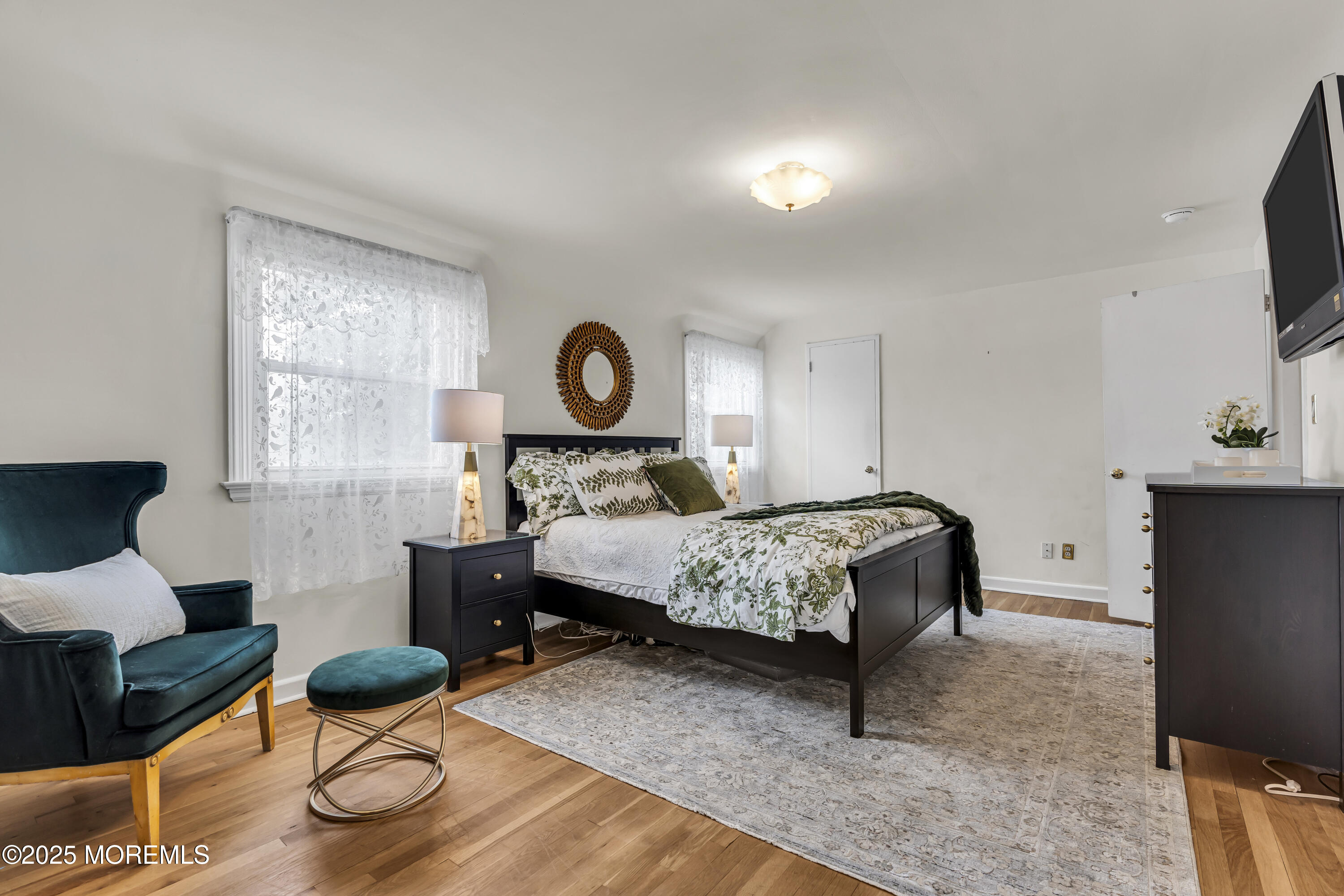 82 Ridge Road Fair Haven, NJ 07704 - Photo 21 of 39 a bedroom with a bed a fireplace and dresser with wooden floor