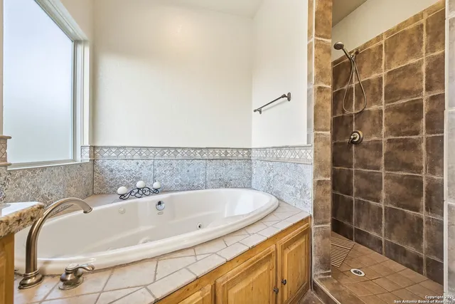 a bedroom with a bed a chandelier and dresser