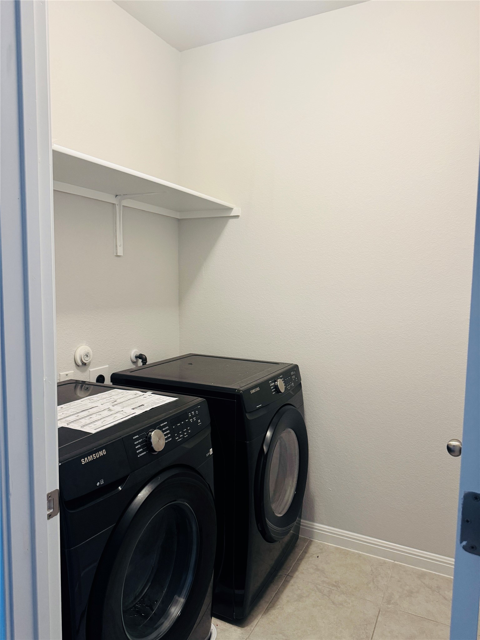 349 Rend Drive Leander, TX 78641 - Photo 13 of 21 Laundry area with washing machine and dryer and light tile patterned floors