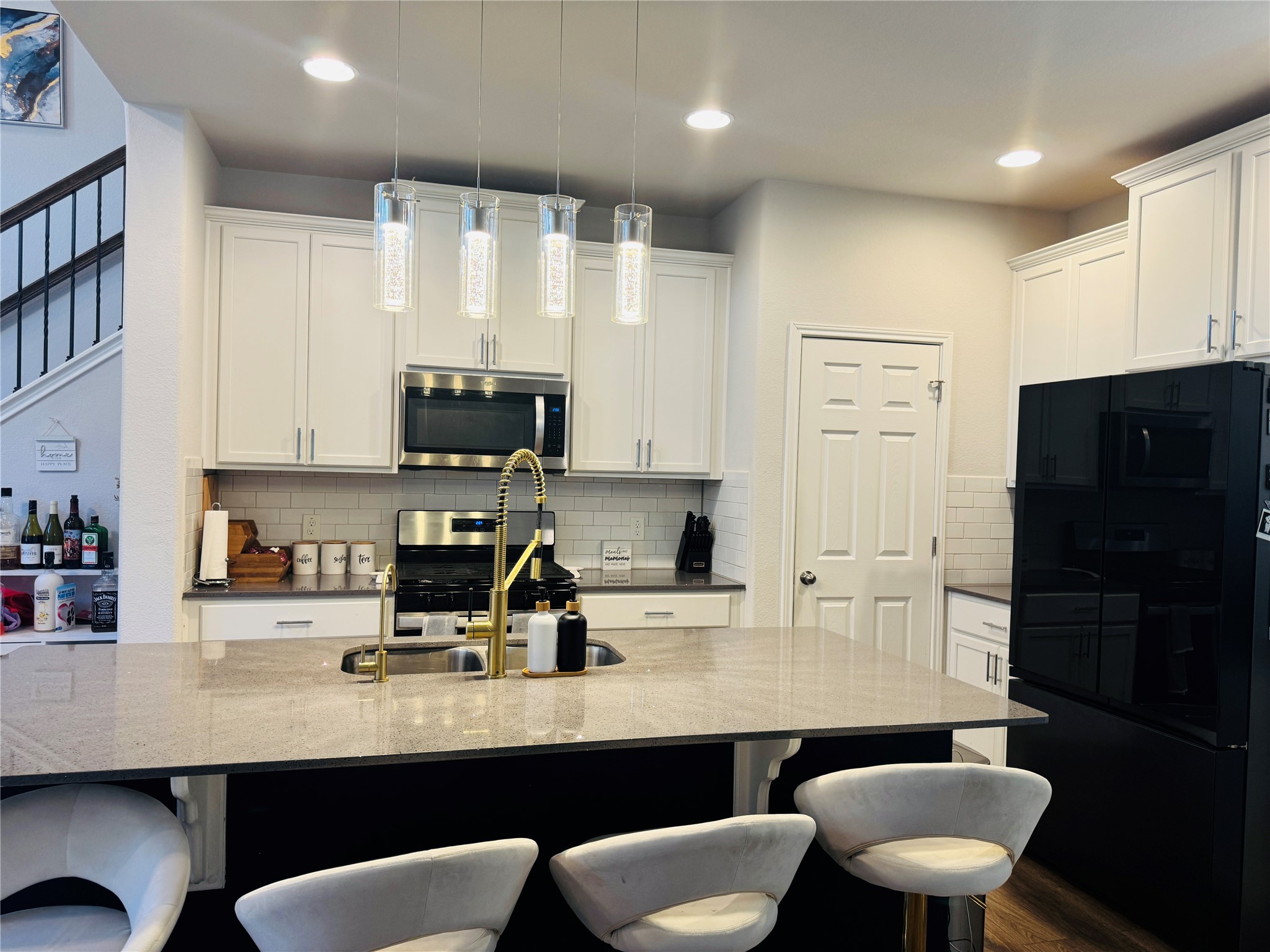 349 Rend Drive Leander, TX 78641 - Photo 7 of 21 Kitchen featuring stainless steel appliances, pendant lighting, white cabinets, and a kitchen bar