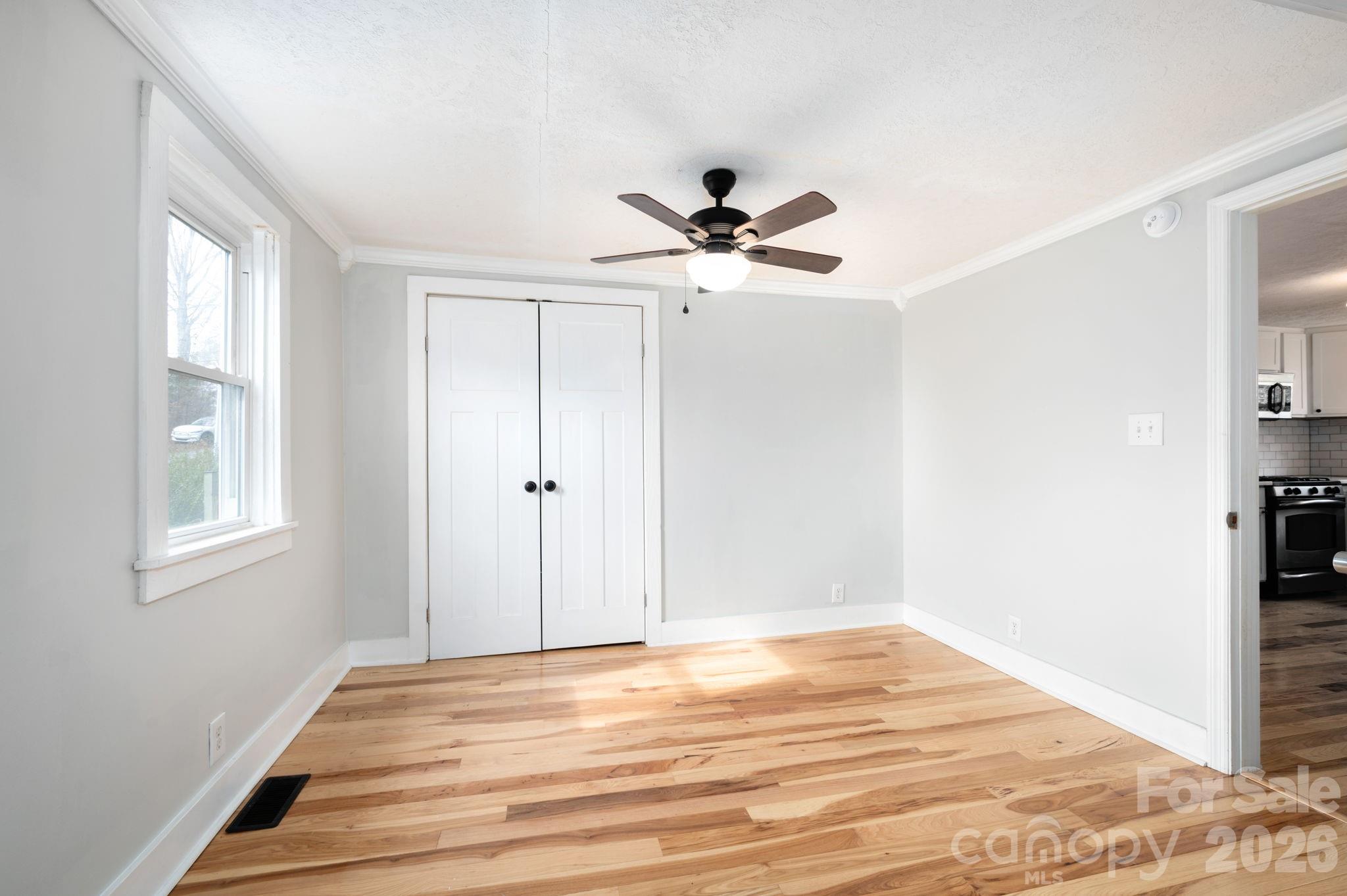 127 Shelburne Road Asheville, NC 28806 - Photo 16 of 28 a view of a room with a ceiling fan and wooden floor