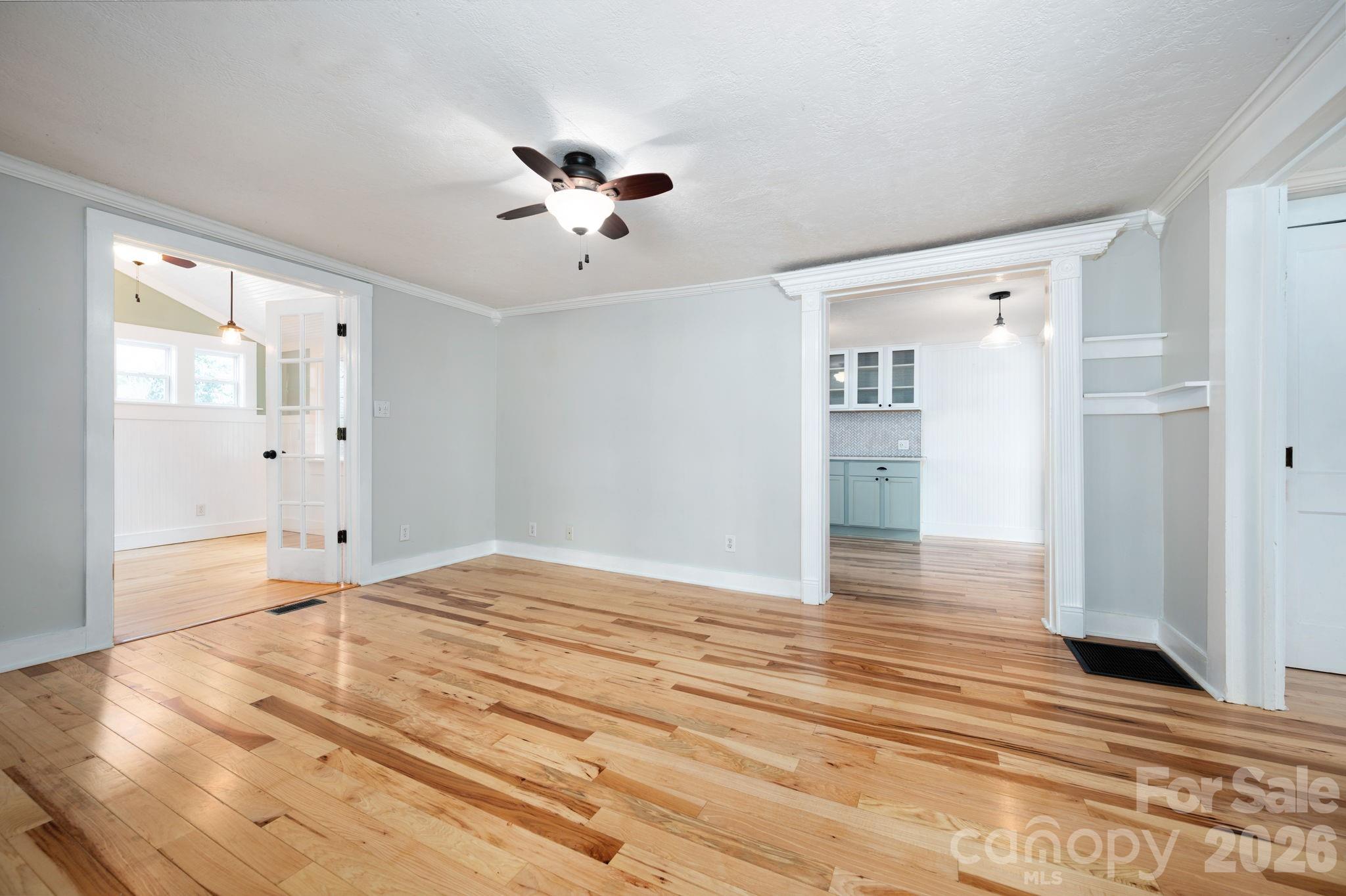 127 Shelburne Road Asheville, NC 28806 - Photo 7 of 28 a view of an empty room with wooden floor and a kitchen