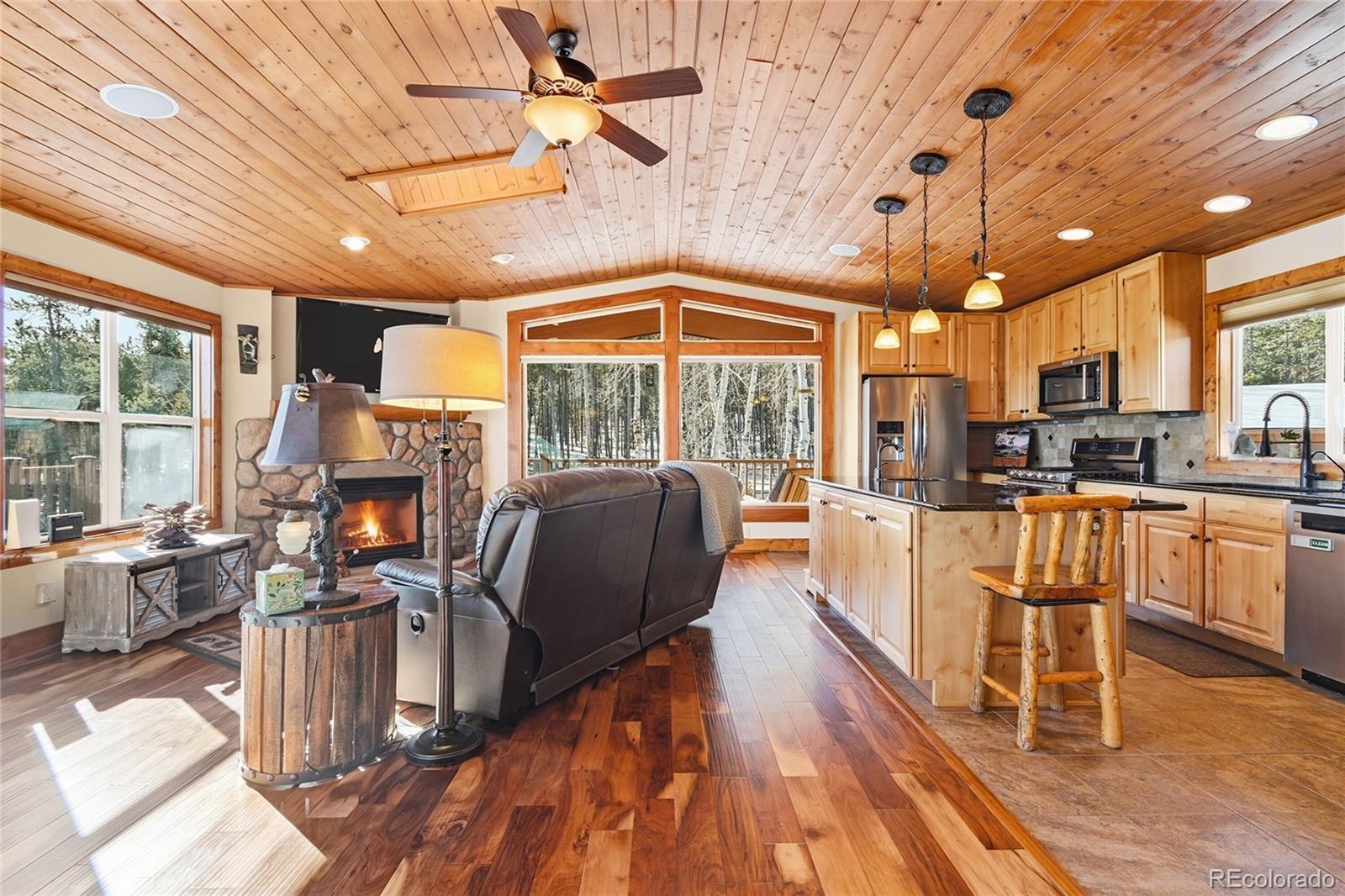 8790 South Warhawk Road Conifer, CO 80433 - Photo 11 of 41 a view of a dining room with furniture a kitchen wooden floor and chandelier