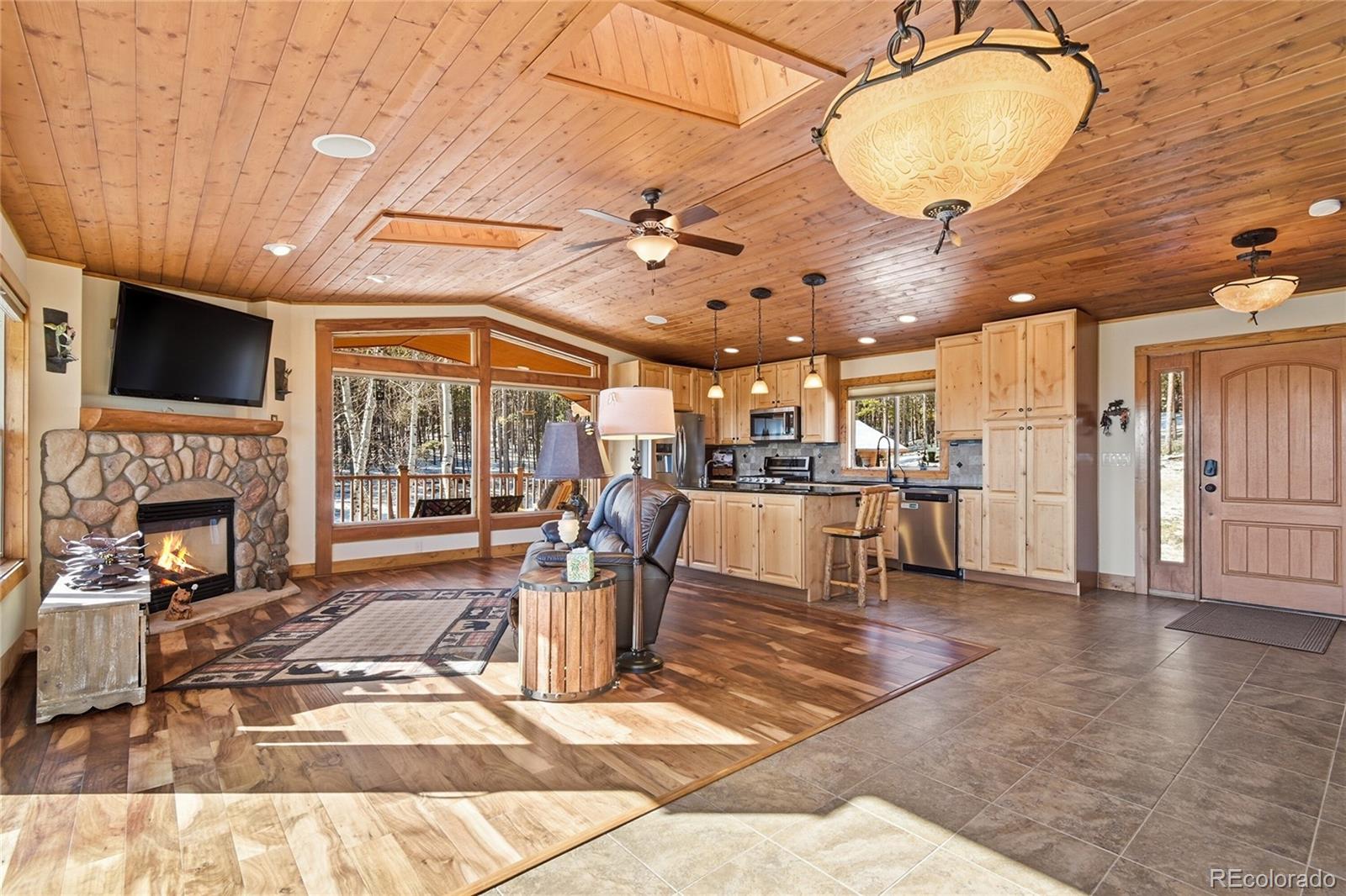 8790 South Warhawk Road Conifer, CO 80433 - Photo 14 of 41 a living room with patio furniture and a fireplace