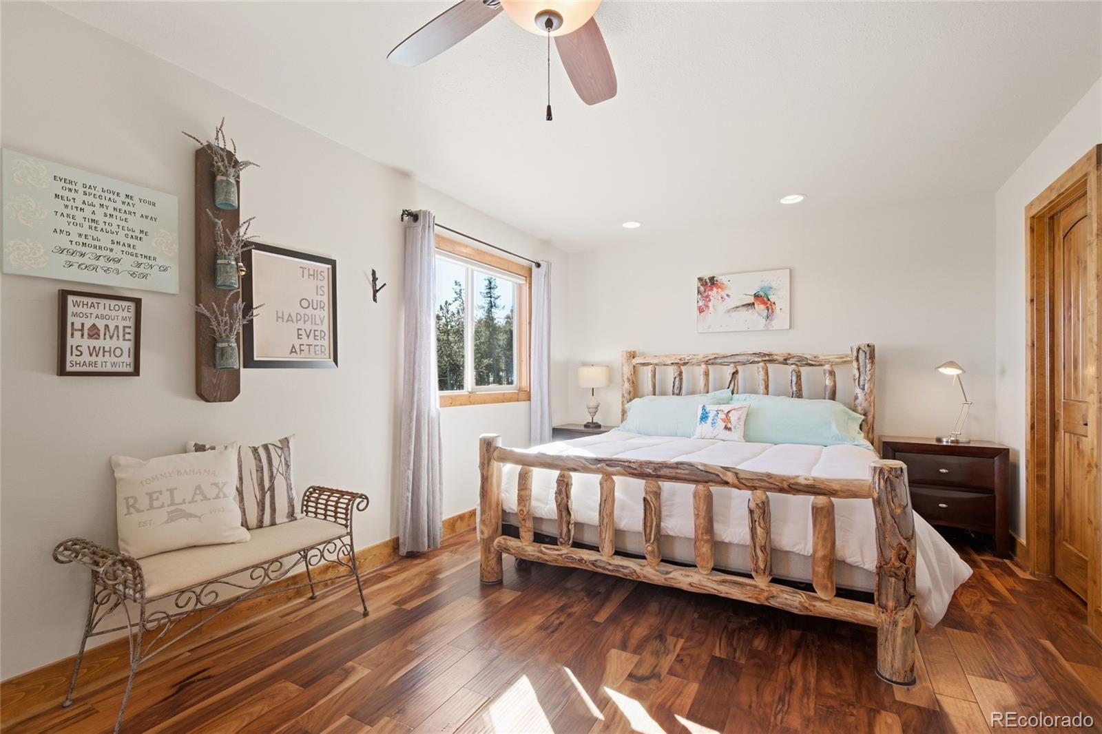 8790 South Warhawk Road Conifer, CO 80433 - Photo 23 of 41 a bedroom with a bed wooden floor and window
