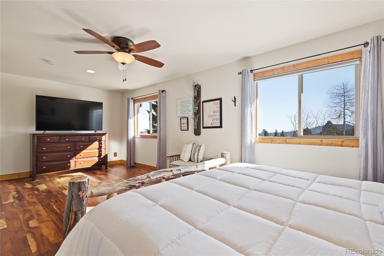 8790 South Warhawk Road Conifer, CO 80433 - Photo 24 of 41 a bedroom with a large bed and a flat screen tv