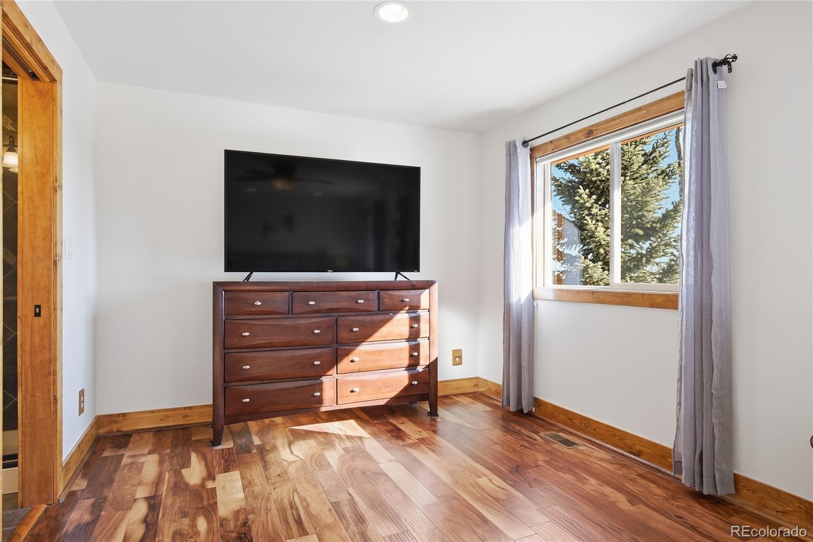 8790 South Warhawk Road Conifer, CO 80433 - Photo 25 of 41 a room with wooden floor and furniture