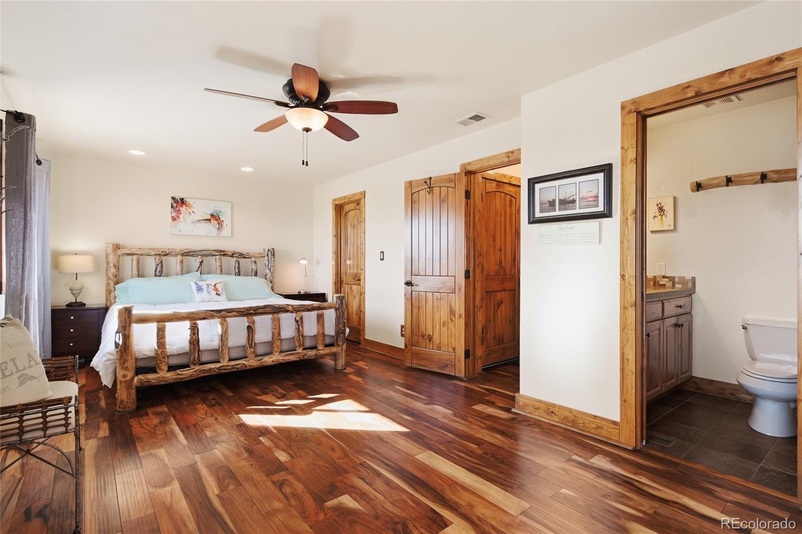 8790 South Warhawk Road Conifer, CO 80433 - Photo 26 of 41 a bedroom with a bed and wooden floor