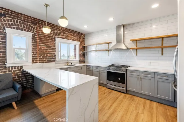 a kitchen with stainless steel appliances granite countertop a stove a sink and a wooden floors