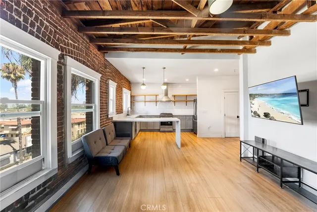 a view of a hallway with wooden floor and a living room