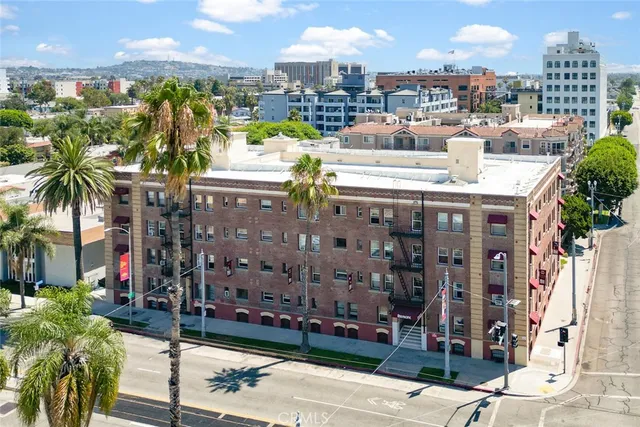 a large kitchen with stainless steel appliances granite countertop a stove a sink dishwasher and a dining table with wooden floor