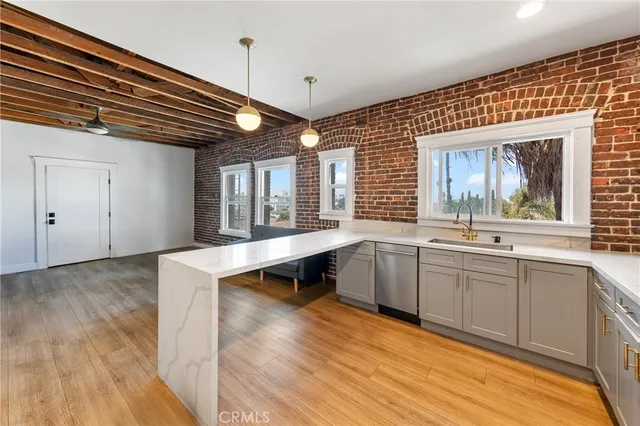 a kitchen with a refrigerator and countertop wooden floor
