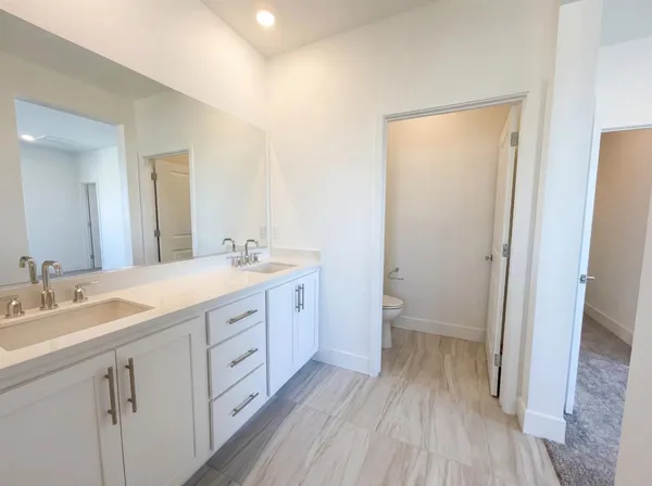 a spacious bathroom with a double vanity sink and a mirror
