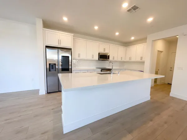 a large kitchen with a large counter top appliances and cabinets