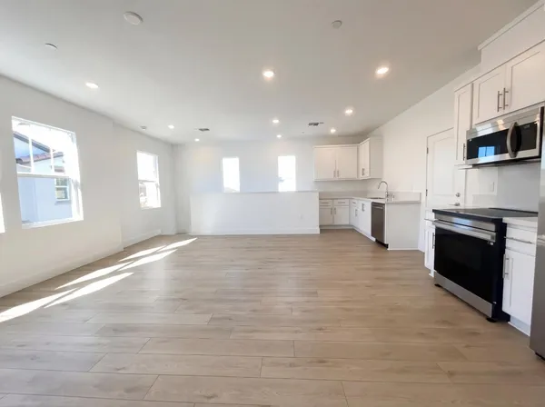 a large kitchen with stainless steel appliances kitchen island granite countertop a large counter top and a stove top oven