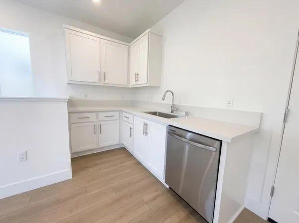 a kitchen with a sink cabinets and wooden floor