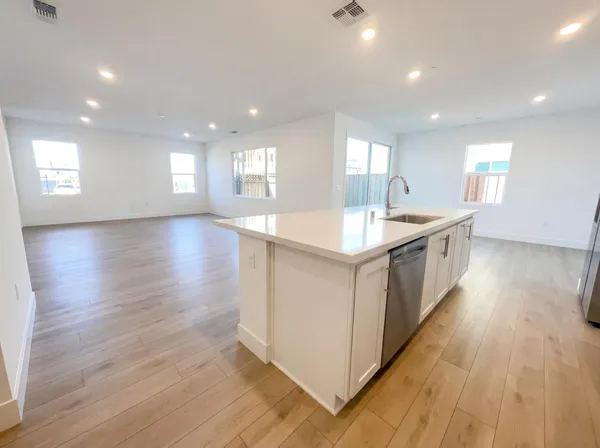 a large kitchen with stainless steel appliances granite countertop a large counter top and wooden floors