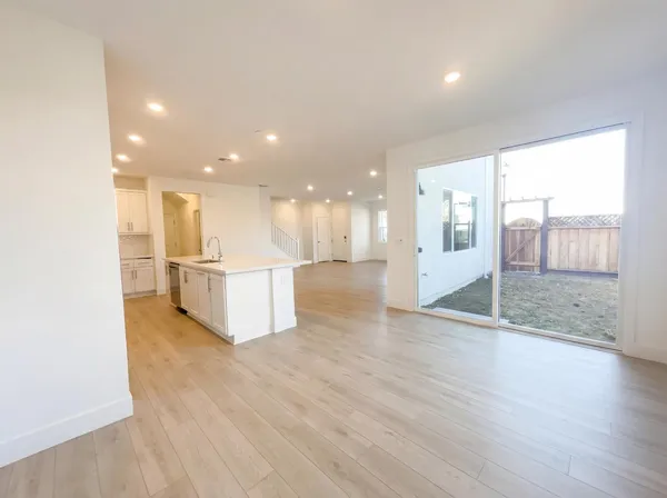 a view of a big room with wooden floor windows and a kitchen
