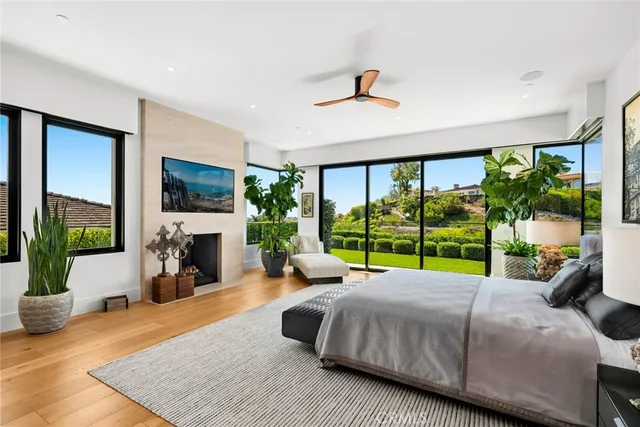 a spacious bedroom with a large bed a flat tv screen and a fireplace