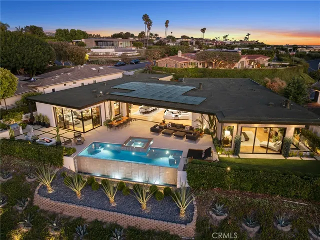an aerial view of a house with a yard fire pit and outdoor seating