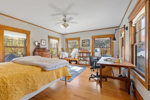 a bedroom with a bed and wooden floor