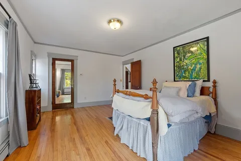 a bedroom with a bed dresser and a window