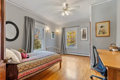 a bedroom with a bed and wooden floor