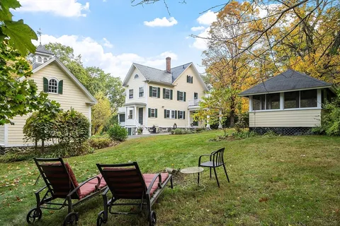 a view of a house with a yard and sitting area