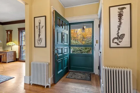 a view of a hallway with wooden floor and a window