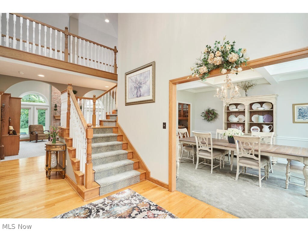 3735 Roberts Ridge Akron, OH 44333 - Photo 18 of 45 Staircase featuring a towering ceiling, carpet, and an inviting chandelier