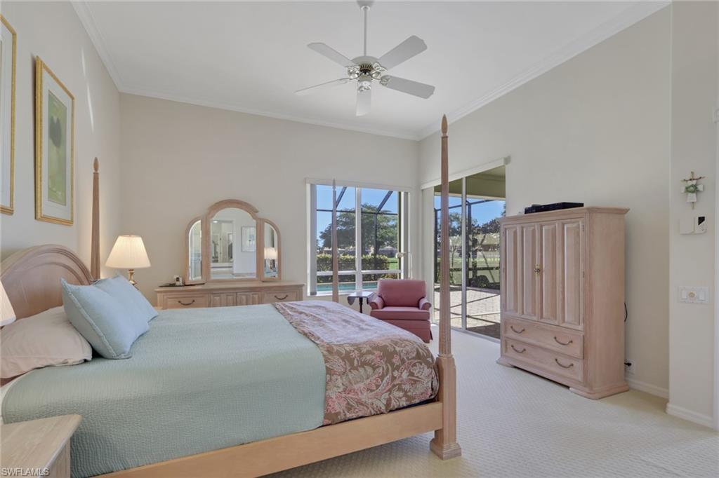 11508 Quail Village Way Naples, FL 34119 - Photo 14 of 37 a bedroom with a large bed and a chandelier