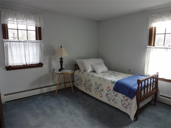 25 Bennett Road Marblehead, MA 01945 - Photo 7 of 15 a bedroom with a bed next to a window and a chandelier