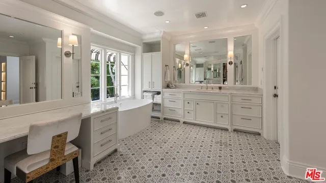 a large bathroom with a large mirror vanity and a sink