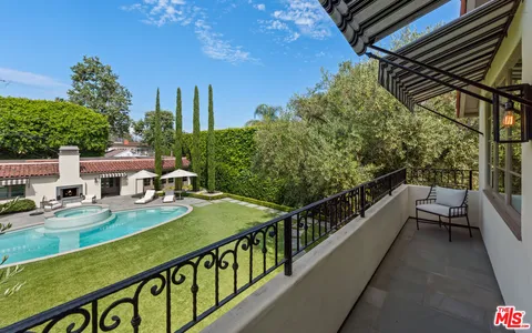 a view of a patio with table and chairs potted plants and large tree
