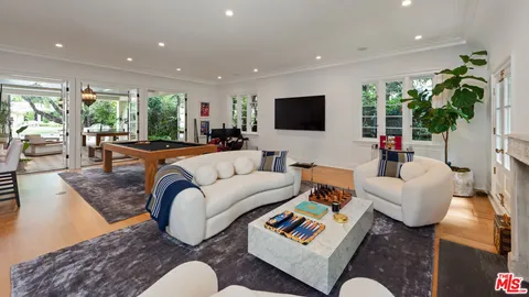 a living room with furniture a flat screen tv and a large window