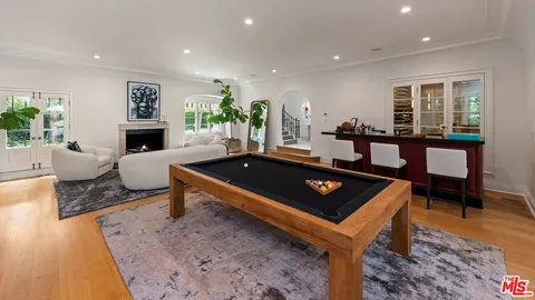 a living room with furniture a rug and a pool table