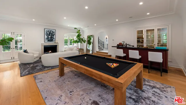 a living room with furniture a rug and a pool table