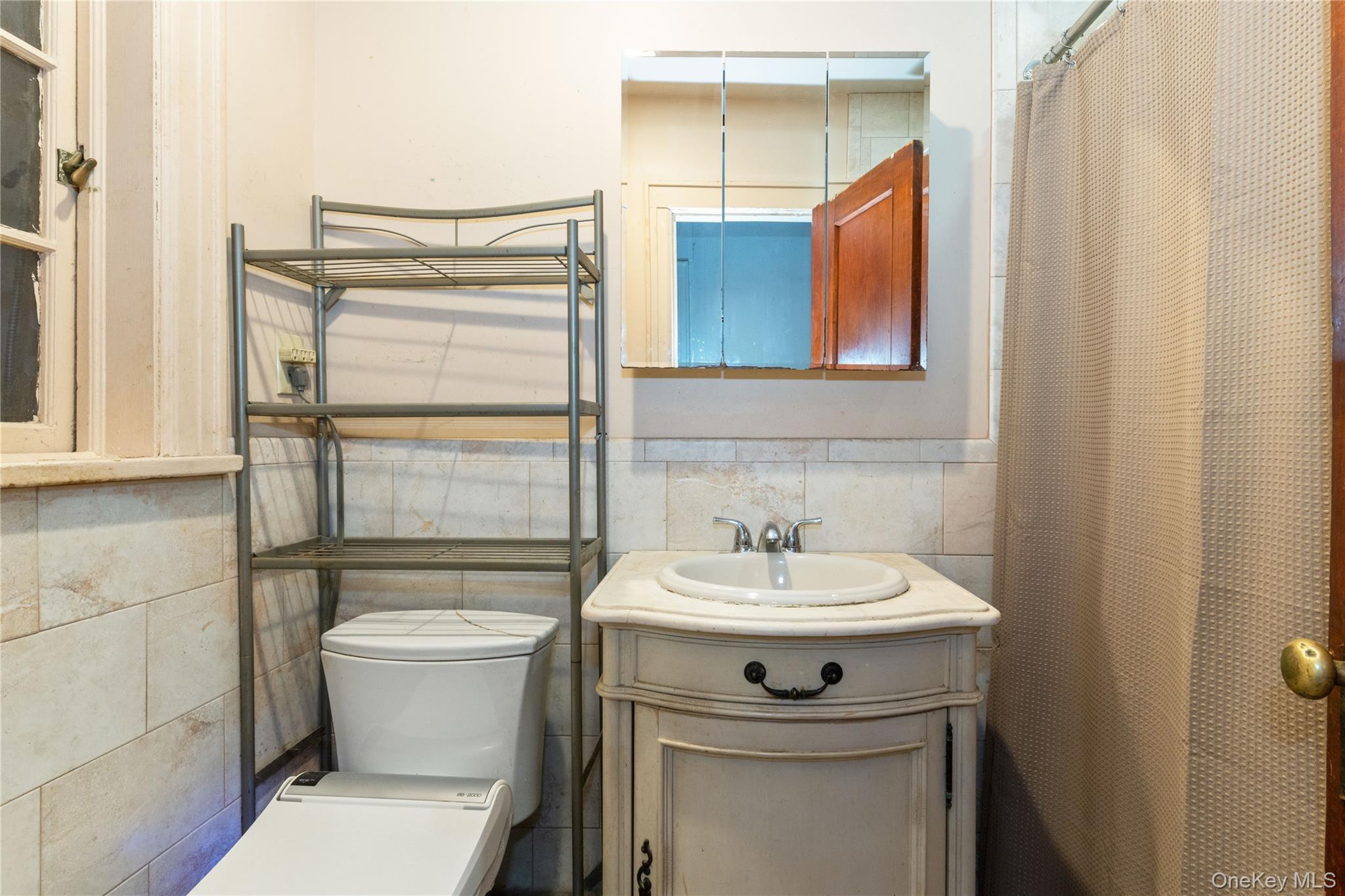 82-72 88th Place Queens, NY 11421 - Photo 18 of 26 a bathroom with a sink toilet and mirror