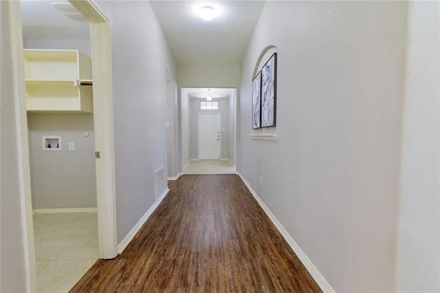 a view of a hallway with wooden floor