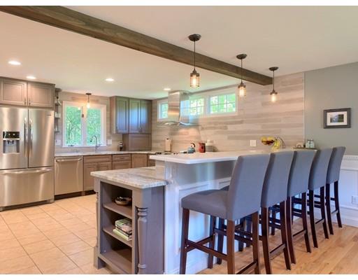 21 Indian Ridge Road Stow, MA 01775 - Photo 8 of 30 a kitchen with stainless steel appliances kitchen island granite countertop a table chairs sink and cabinets
