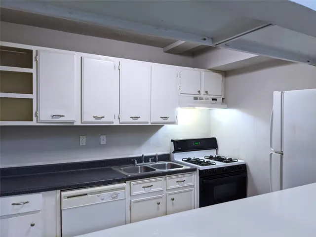 a kitchen with granite countertop a stove and a refrigerator