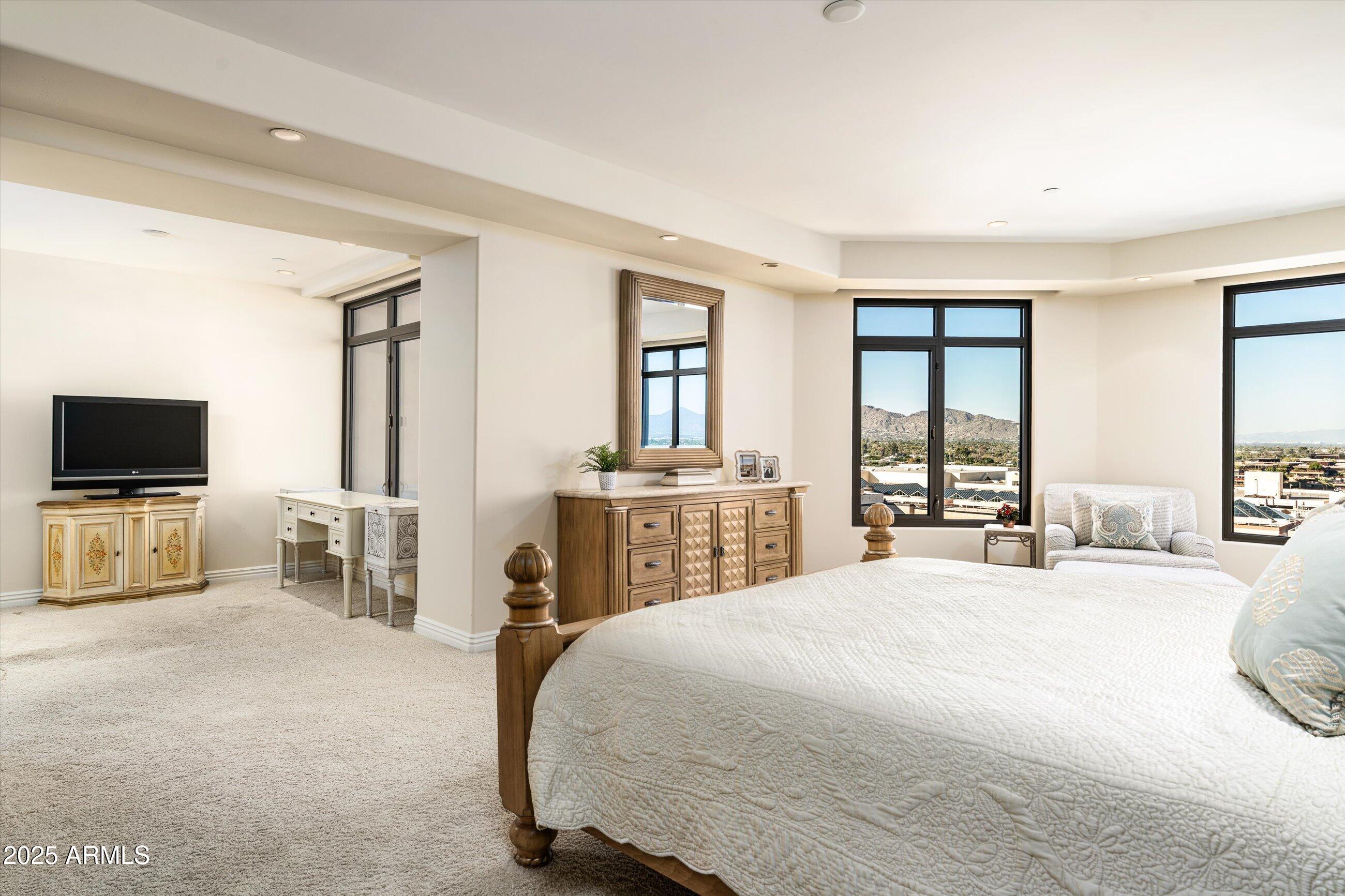 7181 East Camelback Road, Unit 1202 Scottsdale, AZ 85251 - Photo 25 of 47 a bedroom with a bed and a flat screen tv