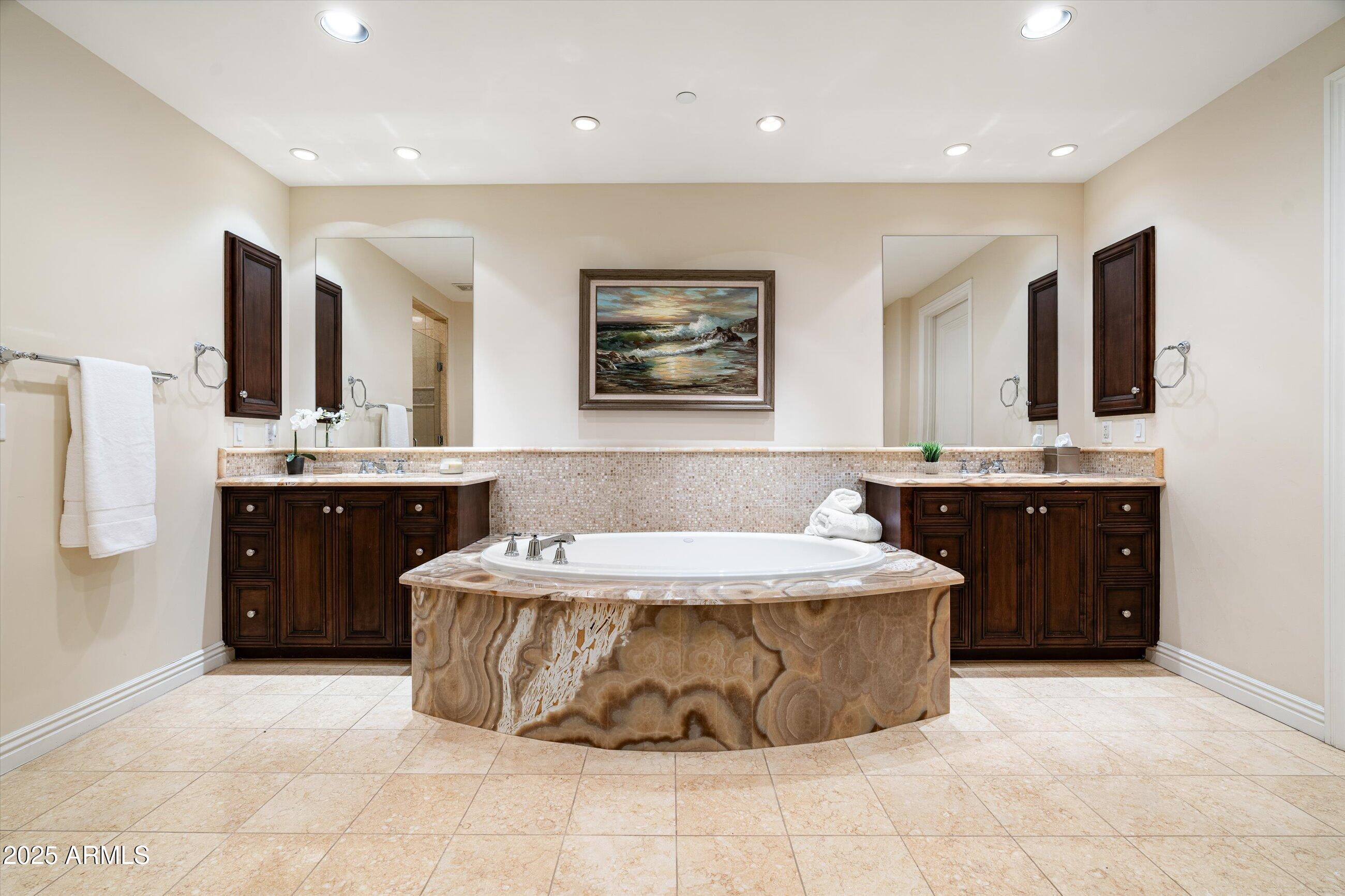 7181 East Camelback Road, Unit 1202 Scottsdale, AZ 85251 - Photo 27 of 47 a spacious bathroom with a tub sink and mirror