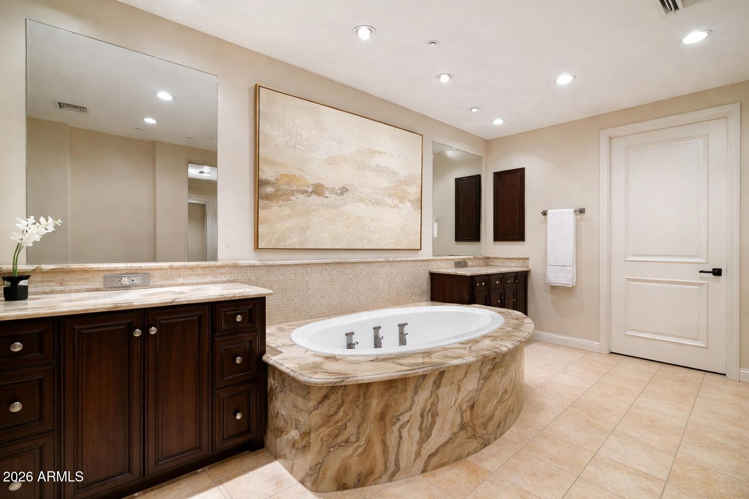 7181 East Camelback Road, Unit 1202 Scottsdale, AZ 85251 - Photo 29 of 47 a bathroom with a tub a sink and a large mirror