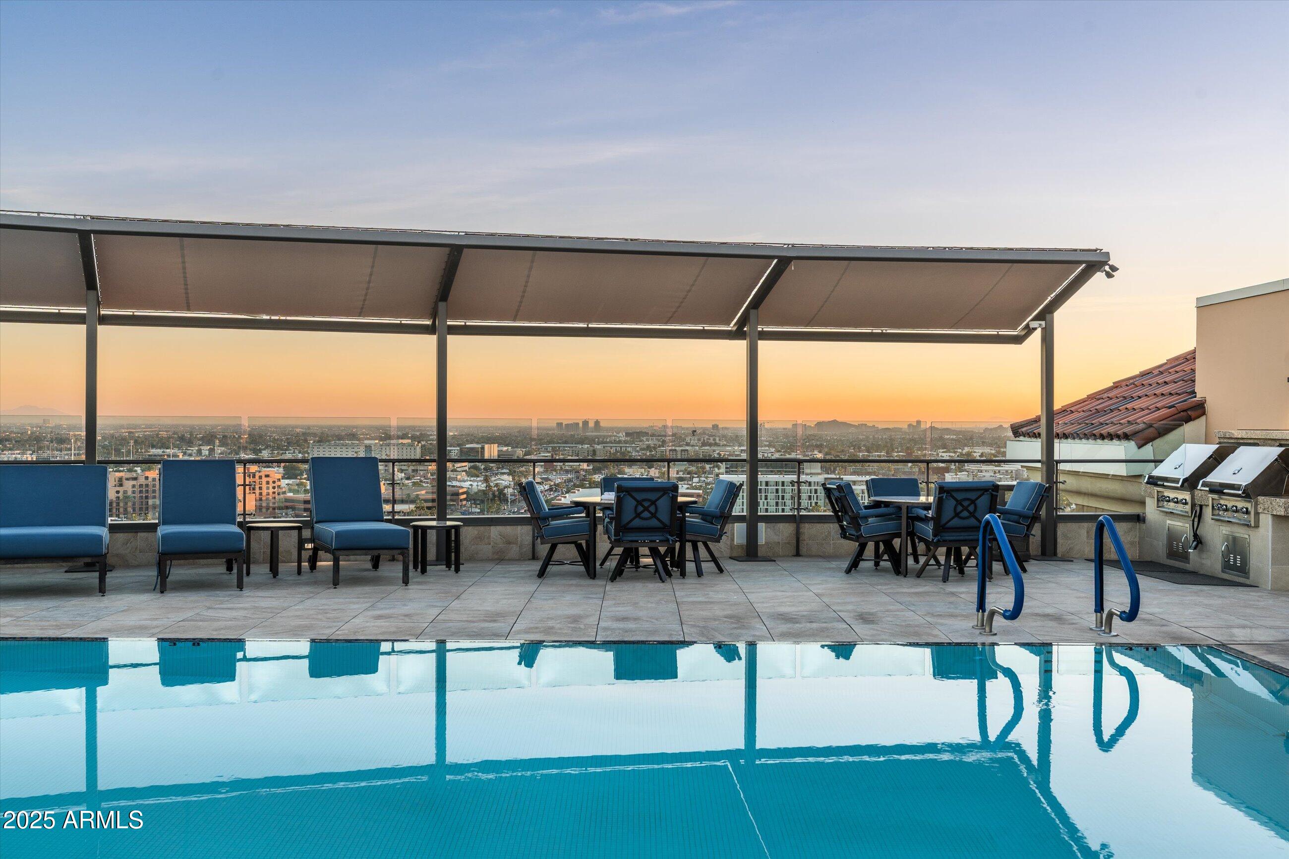 7181 East Camelback Road, Unit 1202 Scottsdale, AZ 85251 - Photo 44 of 47 a swimming pool with outdoor seating and city view