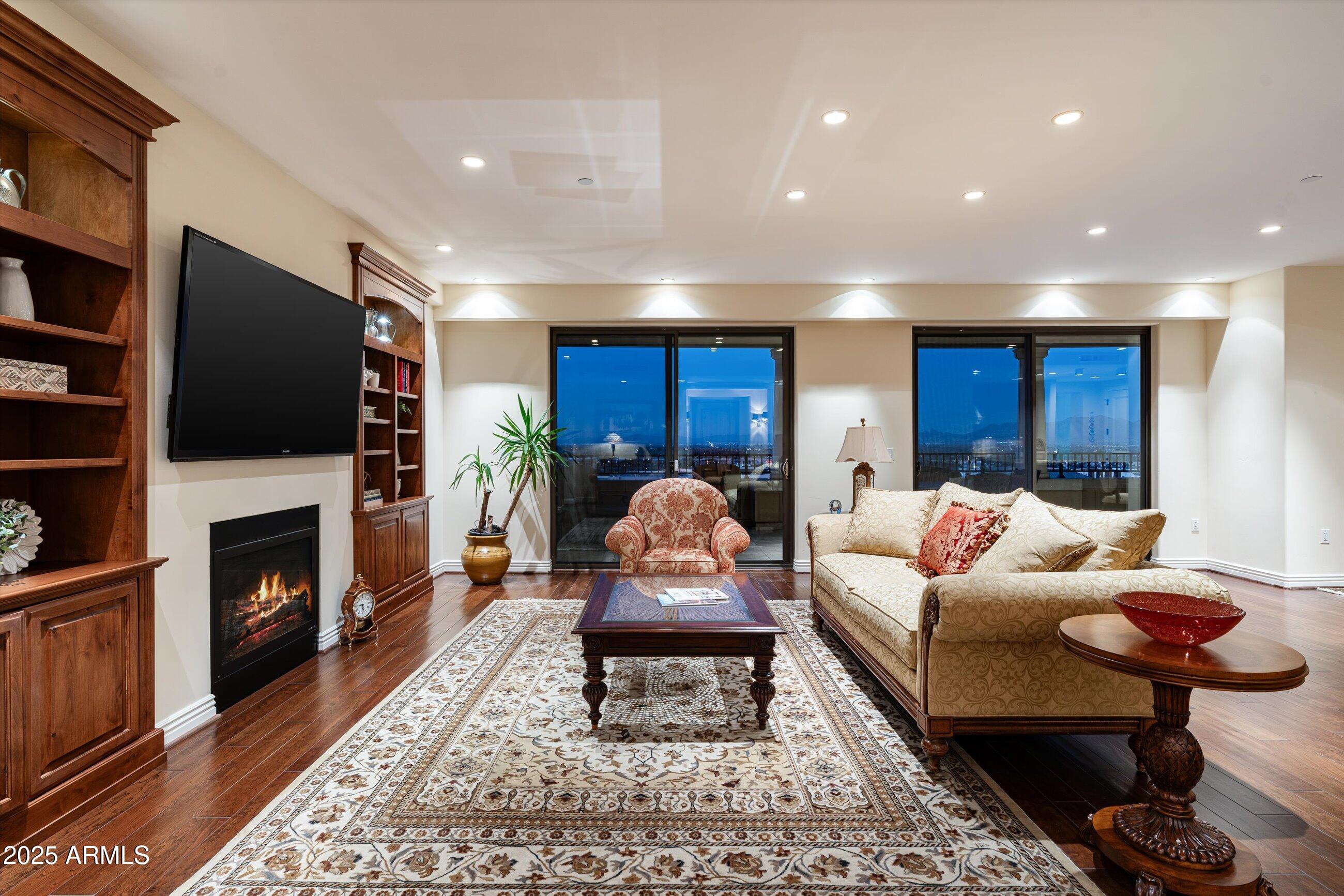 7181 East Camelback Road, Unit 1202 Scottsdale, AZ 85251 - Photo 5 of 47 a living room with furniture a fireplace and a flat screen tv