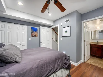 a bedroom with a large bed and a chandelier